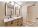 Bathroom features double vanity, light wood cabinets, and black matte fixtures at 5306 Falling Petals Dr, North Las Vegas, NV 89031