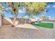 Relaxing backyard with artificial turf, gravel, and shade tree at 5420 Doe Ave, Las Vegas, NV 89146