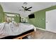 Green-walled bedroom with a comfortable bed, ceiling fan, and mirrored closet doors at 5420 Doe Ave, Las Vegas, NV 89146