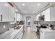 Renovated kitchen featuring white cabinets, stainless steel appliances, and gray tile at 5420 Doe Ave, Las Vegas, NV 89146