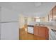 Kitchen with white appliances and wood cabinets, open to living area at 5533 Ramirez St, North Las Vegas, NV 89031