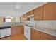 Kitchen with wood cabinets, white appliances, and a double sink at 5533 Ramirez St, North Las Vegas, NV 89031