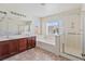 Bright bathroom showcases a double sink vanity, soaking tub, and glass-enclosed shower at 5636 Granville Lake St, North Las Vegas, NV 89031