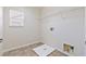 Laundry room with tile floors, a window, and connections for washer and dryer at 5636 Granville Lake St, North Las Vegas, NV 89031