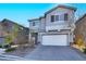 Two-story house with gray siding, white garage door, and landscaping at 5921 Roaring Canyon Ct, Las Vegas, NV 89139