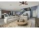 Virtually staged living room with sectional sofa, coffee table, and stairs at 5921 Roaring Canyon Ct, Las Vegas, NV 89139