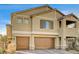 Two-story house with tan siding, brown garage doors, and a landscaped yard at 5969 Viscaya Grove St, Las Vegas, NV 89118