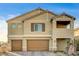 Two-story house with tan siding, brown garage doors, and a landscaped yard at 5969 Viscaya Grove St, Las Vegas, NV 89118