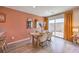 Dining area with wood table, sliding door to patio, and terracotta walls at 6188 Lily Garden St # 110, North Las Vegas, NV 89081