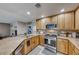 Open kitchen with stainless steel appliances and wood cabinets at 8125 Caramel Gorge Ct, Las Vegas, NV 89143