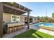 Outdoor kitchen, pool, spa, and pergola create a relaxing backyard oasis at 9820 Maiden Pink Ave, Las Vegas, NV 89149