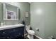 Small bathroom with dark vanity, toilet and decorative mirror at 9820 Maiden Pink Ave, Las Vegas, NV 89149