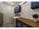 Bright laundry room with built-in cabinets and butcher block counter at 9820 Maiden Pink Ave, Las Vegas, NV 89149