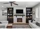 Spacious living room with fireplace, built-in shelving, and hardwood floors at 9820 Maiden Pink Ave, Las Vegas, NV 89149