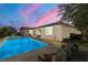 Luxury pool with spa and outdoor seating area at sunset at 9820 Maiden Pink Ave, Las Vegas, NV 89149