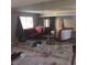 A damaged living room with a red couch, a window, a mirror, and debris scattered throughout at 2612 Cabot St, Las Vegas, NV 89102
