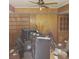 Wood-paneled living room featuring a ceiling fan, built-in shelves, and a large pile of debris at 2612 Cabot St, Las Vegas, NV 89102