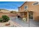 Wide backyard featuring a covered patio, desert landscaping, and brick wall at 3349 Morning Amber St, North Las Vegas, NV 89032