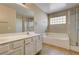 Bathroom with double vanity, bathtub, shower and neutral tile at 3349 Morning Amber St, North Las Vegas, NV 89032