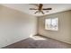 Bright bedroom featuring neutral walls, carpet, a window with neighborhood views and a ceiling fan at 3349 Morning Amber St, North Las Vegas, NV 89032