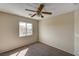 Bright carpeted bedroom with beige walls, a window with neighborhood views and a ceiling fan at 3349 Morning Amber St, North Las Vegas, NV 89032