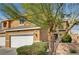 Two-story home with attached garage partially obscured by tree at 3349 Morning Amber St, North Las Vegas, NV 89032