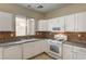A functional kitchen with white appliances, with mosaic backsplash at 3349 Morning Amber St, North Las Vegas, NV 89032