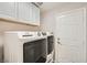 Bright laundry room features modern washer and dryer with cabinets above at 3709 Ferrell St, North Las Vegas, NV 89032
