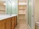 Bathroom vanity area featuring wood cabinets, double sinks, and closet access at 38 E Serene Ave # 134, Las Vegas, NV 89123