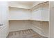 Walk-in closet with installed white shelving and carpeted floor at 38 E Serene Ave # 134, Las Vegas, NV 89123