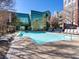 Community pool with lounge chairs and glass building in the background at Manhattan Condominiums at 38 E Serene Ave # 134, Las Vegas, NV 89123