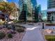 Manicured pathway with lush plants leads to glass building at Manhattan Condominiums at 38 E Serene Ave # 134, Las Vegas, NV 89123