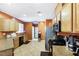 Kitchen with wood cabinets, stainless steel appliances, and orange walls at 4350 New Suffolk St # 1, North Las Vegas, NV 89032