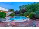 Inviting backyard oasis featuring a sparkling pool, lush landscaping, and a patio area at 4649 Bird View Ct, Las Vegas, NV 89129