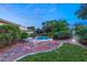 Landscaped backyard with a pool at dusk at 4649 Bird View Ct, Las Vegas, NV 89129