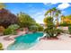 Large freeform swimming pool with waterfall feature and ample patio space at 4649 Bird View Ct, Las Vegas, NV 89129