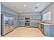 Well-lit kitchen featuring stainless steel appliances and gray cabinets at 5555 Sun Temple Ave, Las Vegas, NV 89139