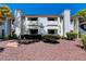 Inviting condo building exterior with landscaping and a rock garden at 6657 W Tropicana Ave # 201, Las Vegas, NV 89103