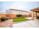 Landscaped backyard with artificial grass, concrete patio, privacy wall, and covered patio at 766 Topocoba St, Las Vegas, NV 89178