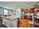Modern kitchen with wood cabinets, stainless steel appliances, an island with granite counters, and wood-look floors at 766 Topocoba St, Las Vegas, NV 89178