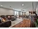Open-concept living space with leather seating, wood floors, ceiling fan, and a view into the kitchen and dining area at 766 Topocoba St, Las Vegas, NV 89178