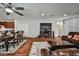 Open-concept living area with hardwood-style flooring, fireplace, leather sectional, and connections to dining and kitchen at 766 Topocoba St, Las Vegas, NV 89178