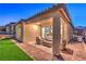 Covered patio with wicker furniture, offering a relaxing space in the backyard at 92 Stone Bluff Ln, Henderson, NV 89011