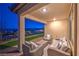 Covered patio with wicker furniture, offering scenic views and a relaxing atmosphere at 92 Stone Bluff Ln, Henderson, NV 89011