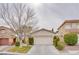 Beige house with two-car garage and landscaping at 10605 Moon Flower Arbor Pl, Las Vegas, NV 89144