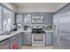 Modern kitchen with gray cabinets, stainless steel appliances, and white countertops at 10605 Moon Flower Arbor Pl, Las Vegas, NV 89144