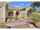 Front entry of house with walkway, arched entryway, and desert landscaping at 1647 Fieldbrook St, Henderson, NV 89052