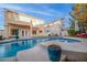 Sparkling blue pool with spa, spacious deck, and adjacent two-story home at 179 Andada Dr, Henderson, NV 89012