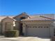 Tan house with tile roof, two-car garage, and landscaping at 22 Arborfield Ct, Henderson, NV 89012