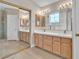 Bathroom boasts dual sinks with wood cabinetry, a large mirror, and a glass-enclosed shower at 2617 Huber Heights Dr, Las Vegas, NV 89128